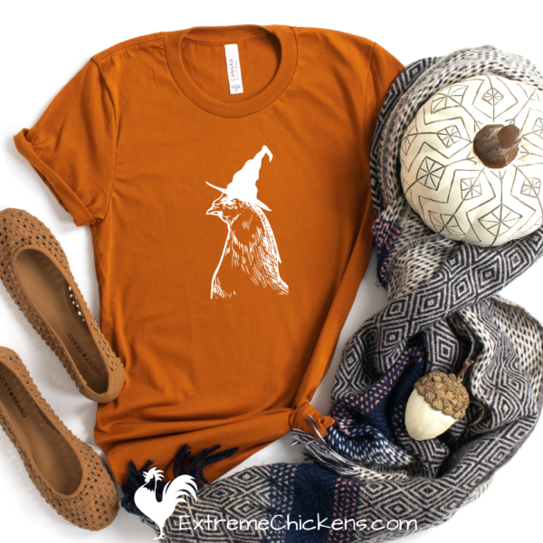 Witchy Chicken Short-Sleeve Unisex T-Shirt mockup with decorated pumpkin, scarf, and ballet flats.